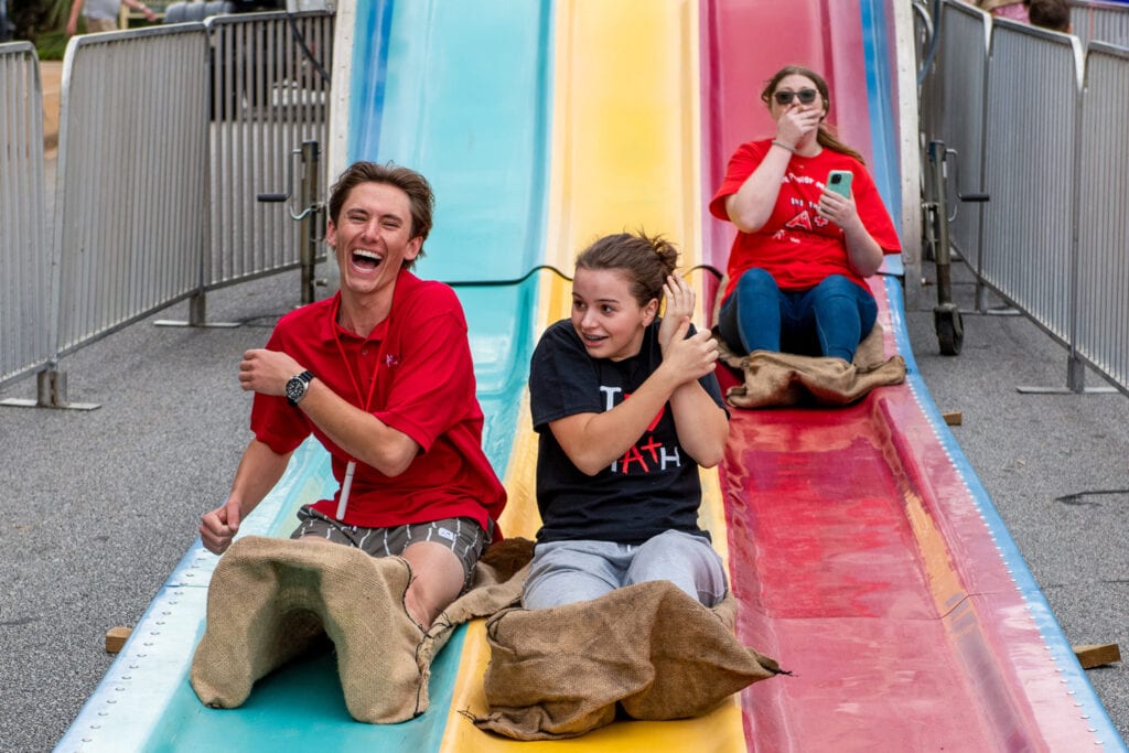Some happy people arrive at the bottom of the giant slide.