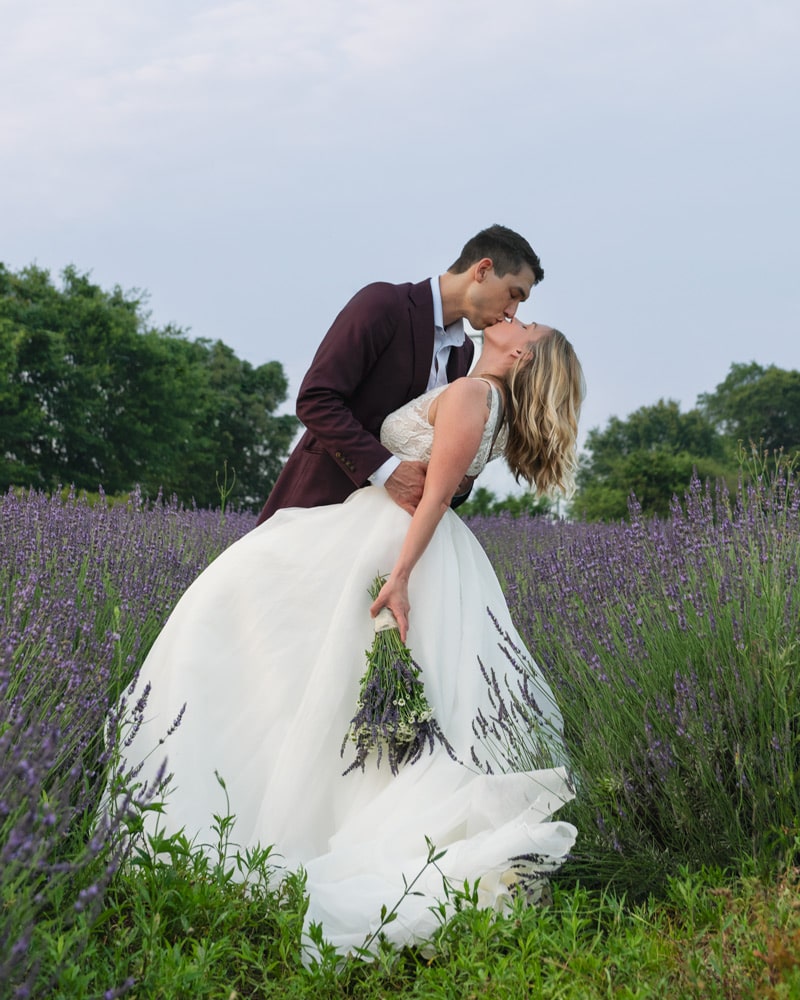 A couple kiss in a lavender field in the Upstate of South Carolina.