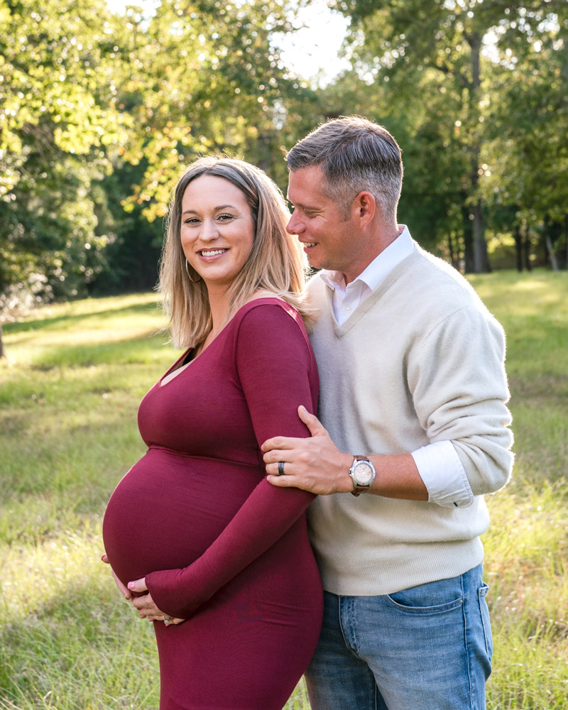 Patrick and Savannah pose for a maternity portrait outdoors in a field.