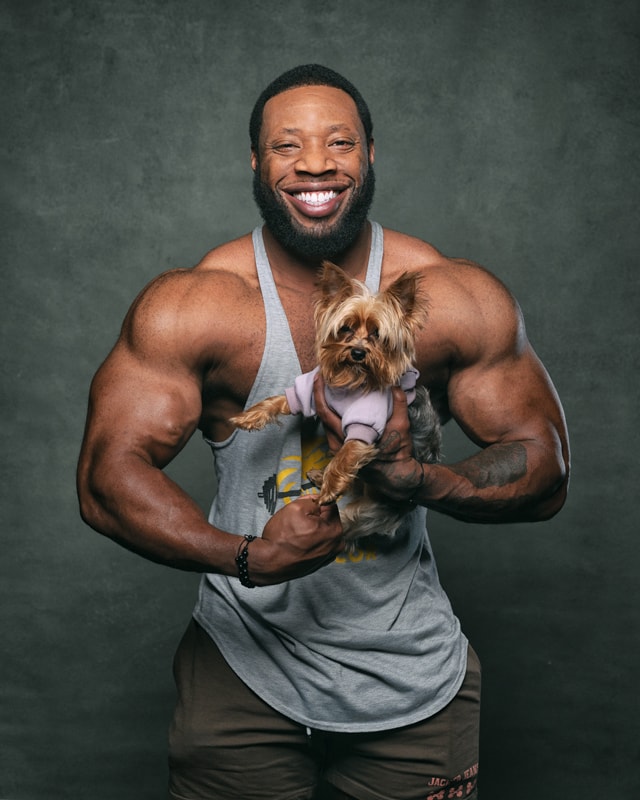 Bodybuilder Cory Curtis poses with his dog BB in the studio.